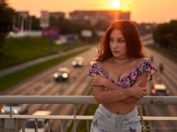 piękna brunetka pozująca na moście z samochodami w tle podczas sesji fotograficznej Dariusza Czepiela w Krakowie